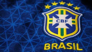 Renderização conceitual da nova camisa azul da seleção brasileira para a Copa do Mundo de 2026, com detalhes dourados e escudo da CBF.