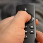 Lado a lado dos dispositivos de streaming Fire TV Stick da Amazon e Xiaomi TV Stick sobre uma mesa, com foco em tecnologia para Smart TV.