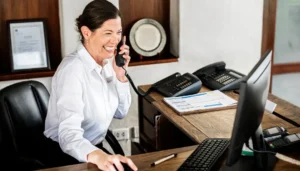 Mulher sorridente em uma recepção moderna, usando um tablet para atendimento, com um certificado digital ao fundo.