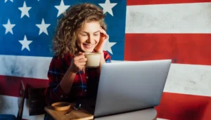 Pessoa digitando um e-mail profissional em inglês em um laptop, com ícones de comunicação e ferramentas de correção ao fundo.