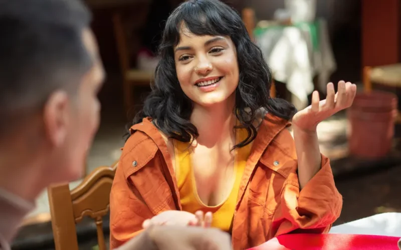 Pessoa sorrindo e falando espanhol com confiança, superando o medo do portunhol em uma conversa