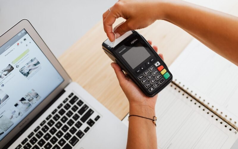 Jovem utilizando notebook para estudar curso de operador de caixa online, com certificado digital em destaque na tela.