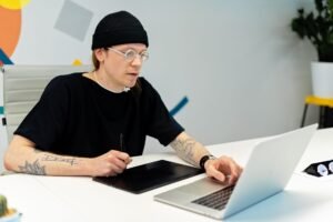 Gráfico de barras mostrando tendências salariais para designers gráficos freelancers em 2026, com ícones de computador e dinheiro.